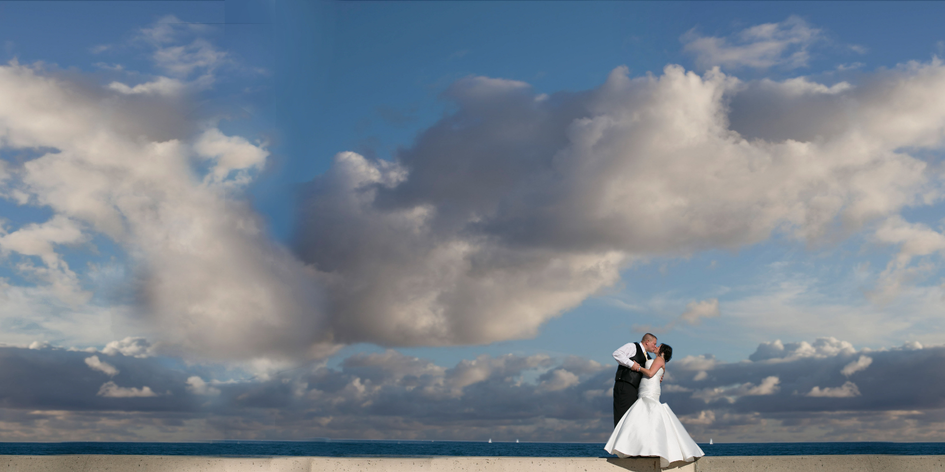 Bride and groom kissing under an umbrella in the rain