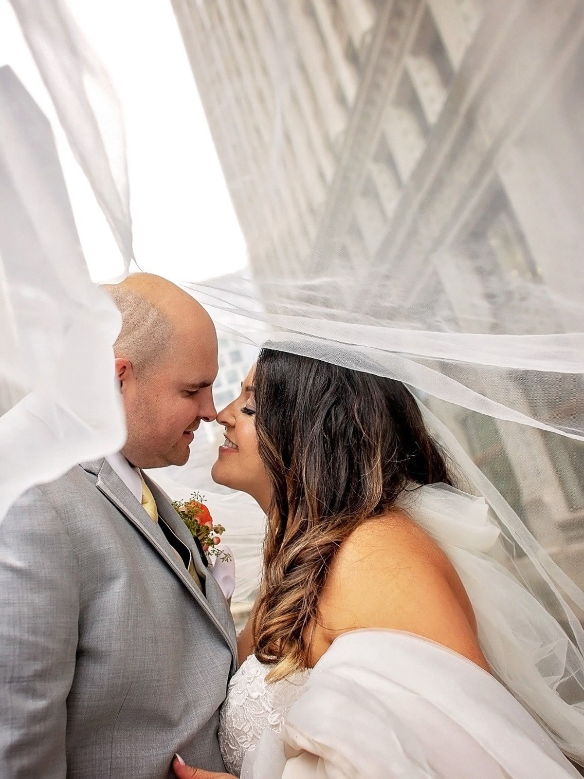 Bride and groom sharing a moment beneath her veil