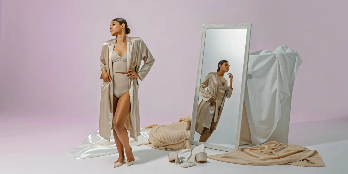Woman posing confidently by a mirror at a luxury Naperville boudoir photographer's studio.